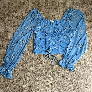 This is blue blouse with sheer sleeves. It also has white flowers.